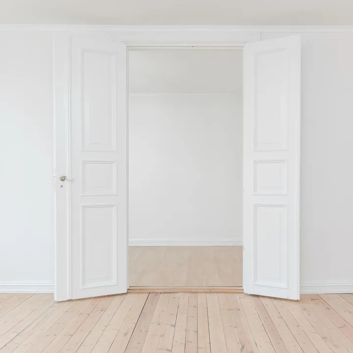 vit dörr i ett tomt rum