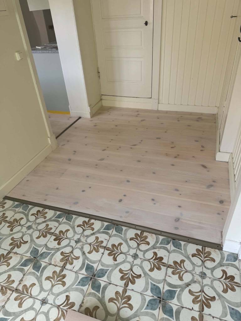 Bild 2 av referensprojekt Renovering av kraftigt slitet trägolv – slipning & vitvaxad finish