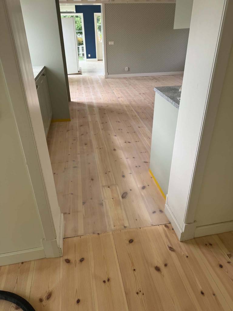 Bild 3 av referensprojekt Renovering av kraftigt slitet trägolv – slipning & vitvaxad finish